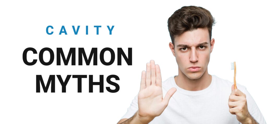 A man's palm facing outward as a "stop" gesture, holding a toothbrush in the other hand, symbolizing the rejection of a common cavity myth, set against a clean background for clarity.